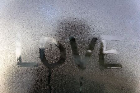 drawn text word love on wet glass. romantic conceptの写真素材