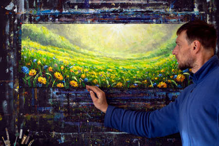 Male artist paint draw in studio panorama painting Meadow in spring and summer wildflowers daisies in flower field. Artist work on Original oil paintingの写真素材