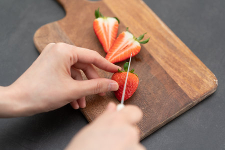 slicing a strawberry on a cutting board