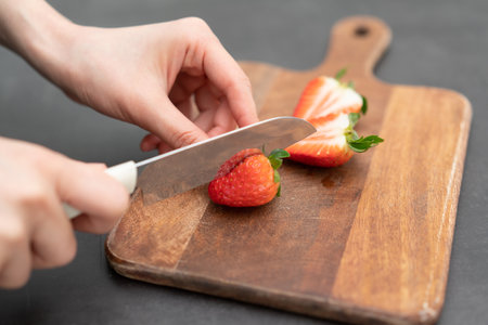 slicing a strawberry on a cutting boardの写真素材