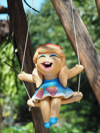 Ceramic Smiley Girl Doll On A Swingの素材