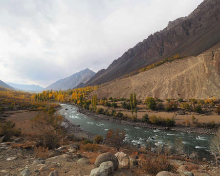 Golden Autumn Mountains And Lake Along Hindu Kush Mountain Range In Ghizer Valley, Northern Pakistanの写真素材