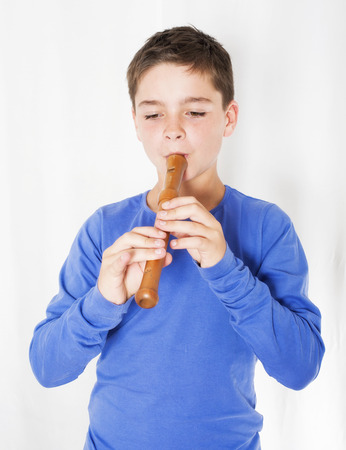 young boy playing on a fluteの写真素材