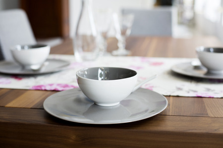 closeup of cup and plate on wooden tableの写真素材