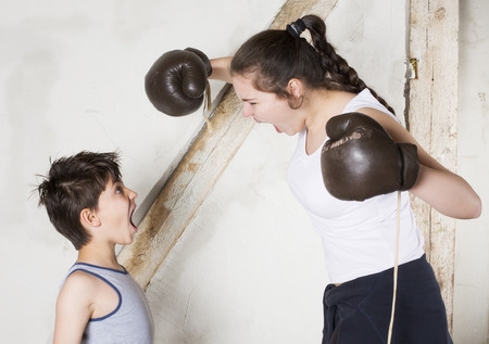 a young boy and a teenage girl are boxingの写真素材