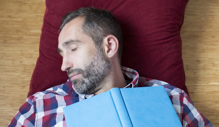 man sleeping and holding a book