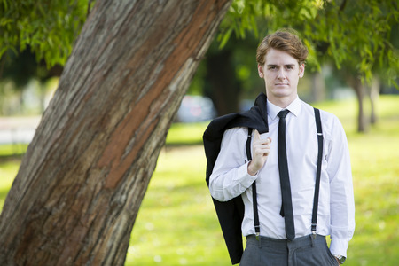handsome man in a suit standing in a parkの写真素材