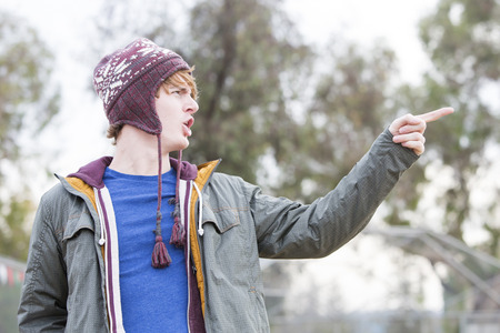 young man in a hat showing something with his fingerの写真素材