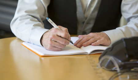 close-up of a man's hands signing a paper