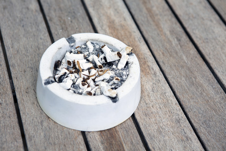 closeup of an ashtray on a wooden tableの写真素材