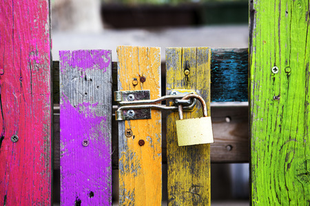 old multicolored wooden fence with a lockの写真素材