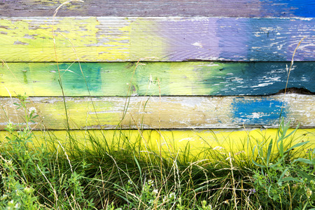 colorful wooden fence painted and with grassの写真素材