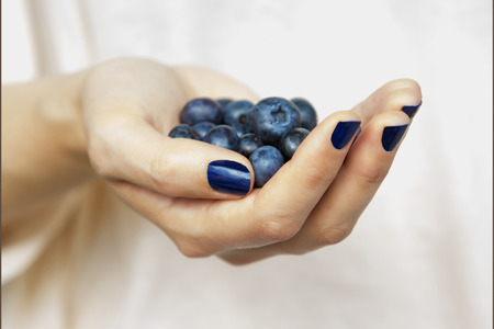 closeup of woman's hand full of blueberriesの写真素材