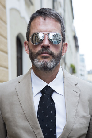 portrait of businessman standing in the street wearing sunglassesの写真素材