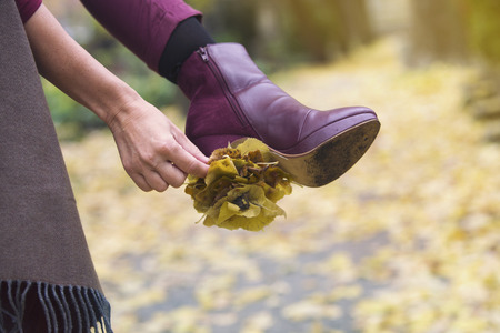closeup of woman's shoe outdoors with leaves stuck on her healの写真素材