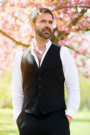 portrait of handsome man in front of cherry blossomの写真素材