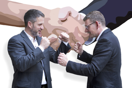 two businessmen are fighting in front fo painting of handshake