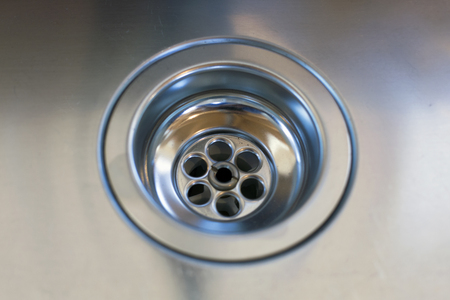 close up of a stainless steel sink plug hole