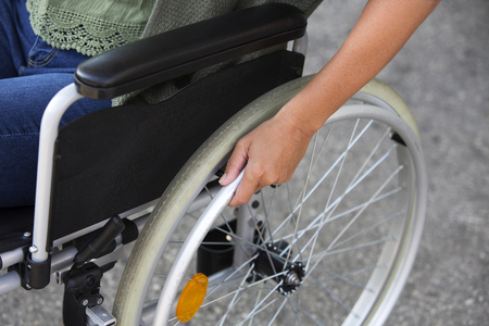 closeup of woman sitting in a wheelchair outsideの写真素材