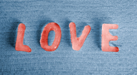 the word Love as red icecubes on blue backgroundの写真素材