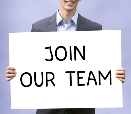 young businessman holding chalkboard with the words Join Our Teamの写真素材