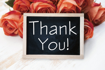 orange roses and blackboard with the words Thank You on wooden tableの写真素材