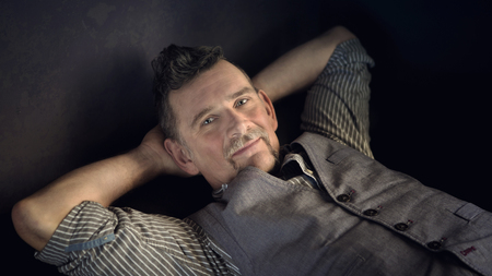 portrait of handsome stylish man in his 50s lying on couch