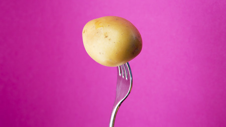 fork with potato on a purple backgroundの写真素材