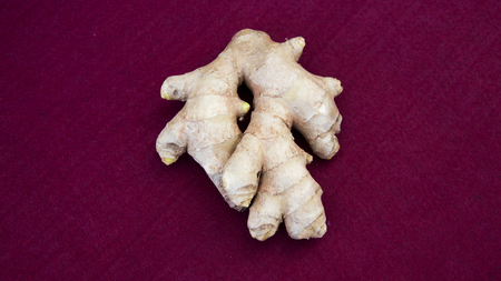 closeup of piece of ginger on a red table