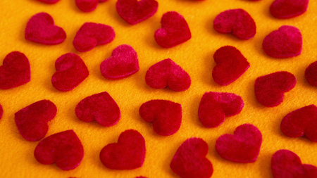 closeup of many red soft hearts on yellow table