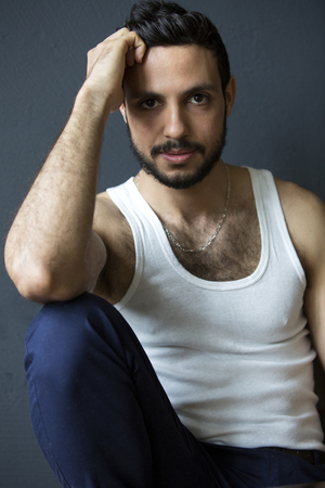 Portrait Of Handsome Young Dark Haired Man Sitting At Table