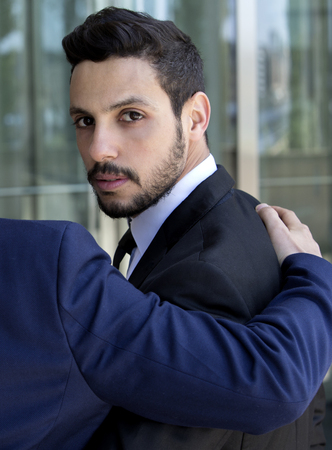 handsome businessman looking over his shoulder at cameraの写真素材