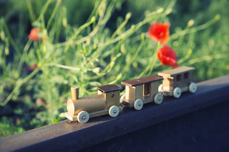 small wooden toy train on real railway tracksの写真素材