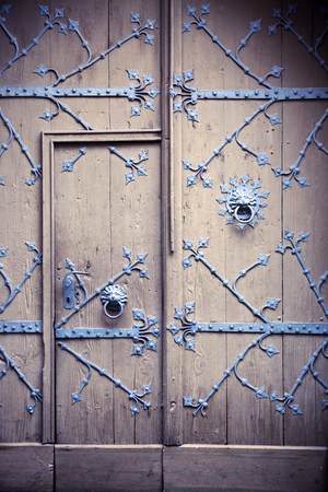 Old rustic wooden door with iron lion headの写真素材