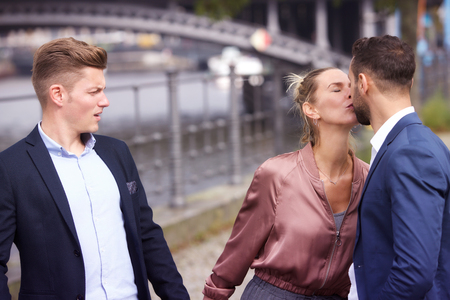 woman kissing man while another is upset and watching