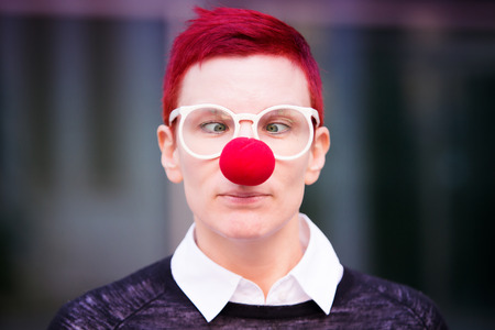 portrait of red-haired beautiful woman with red nose and cross-eyedの写真素材