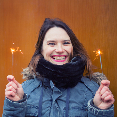 portrait of beautiful young woman outdoors holding sparklers
