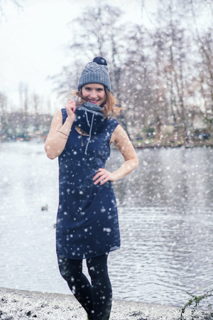 beautiful young woman standing outside in the snow without a coatの写真素材