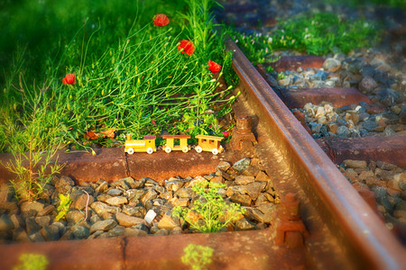 small wooden toy train on real railway tracksの写真素材