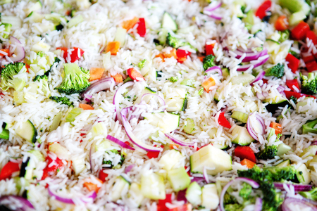 closeup of white rice with broccoli, onions, zucchini and red paprikaの写真素材