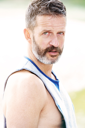 bearded handsome muscular athlete standing outdoorsの写真素材