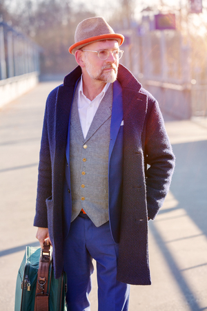handsome man in his 50s walking with his suitcaseの写真素材