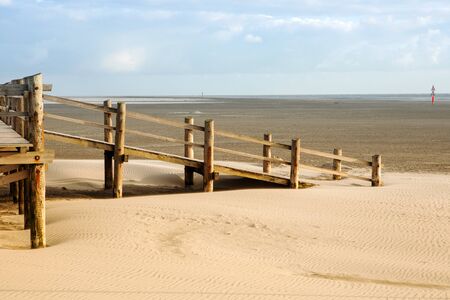 wooden deck in the sand by the ocean