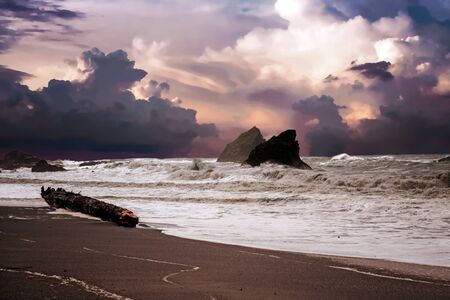 beach and rocks and wild waves on a cloudy rainy day