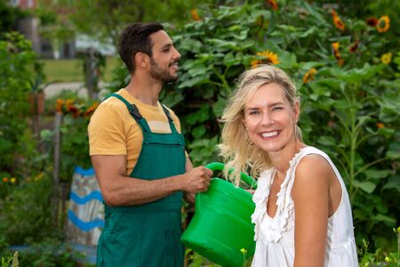 beautiful couple in the garden watering the flowers