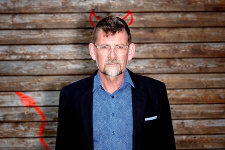 portrait of handsome businessman with drawn devils horns