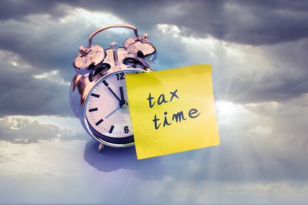 alarm clock with tax time and grey cloudy sky