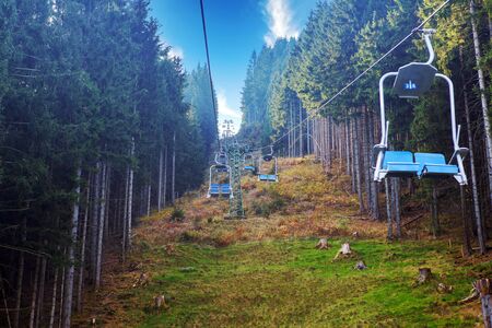 blue chair lifts going up the mountain through forest