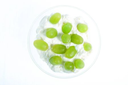 glass bowl with yogurt and green grapesの写真素材