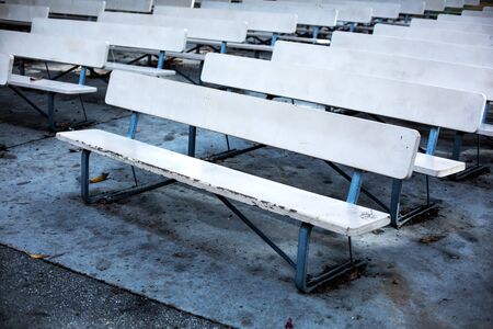 rowa of white empty benches at an outdoor theaterの写真素材